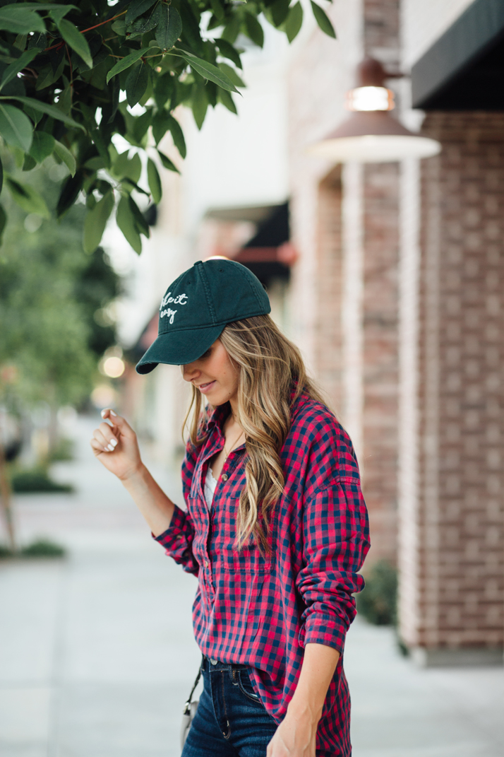 green baseball cap and red plaid shirt