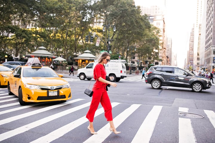 a bold red jumpsuit and nude heels in NYC