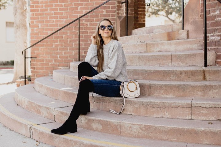 black over the knee boots and a gray sweater