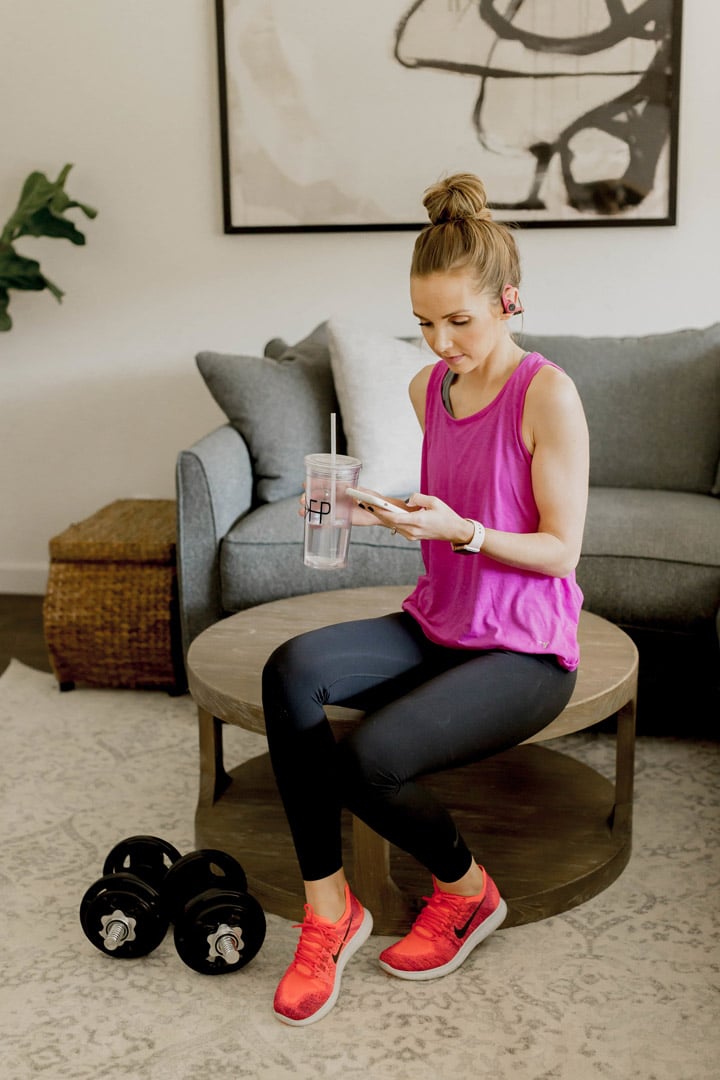 pink tank with black zella leggings doing sweat app at home