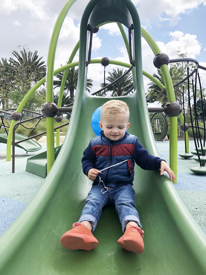 sanny sliding down the slide at the park