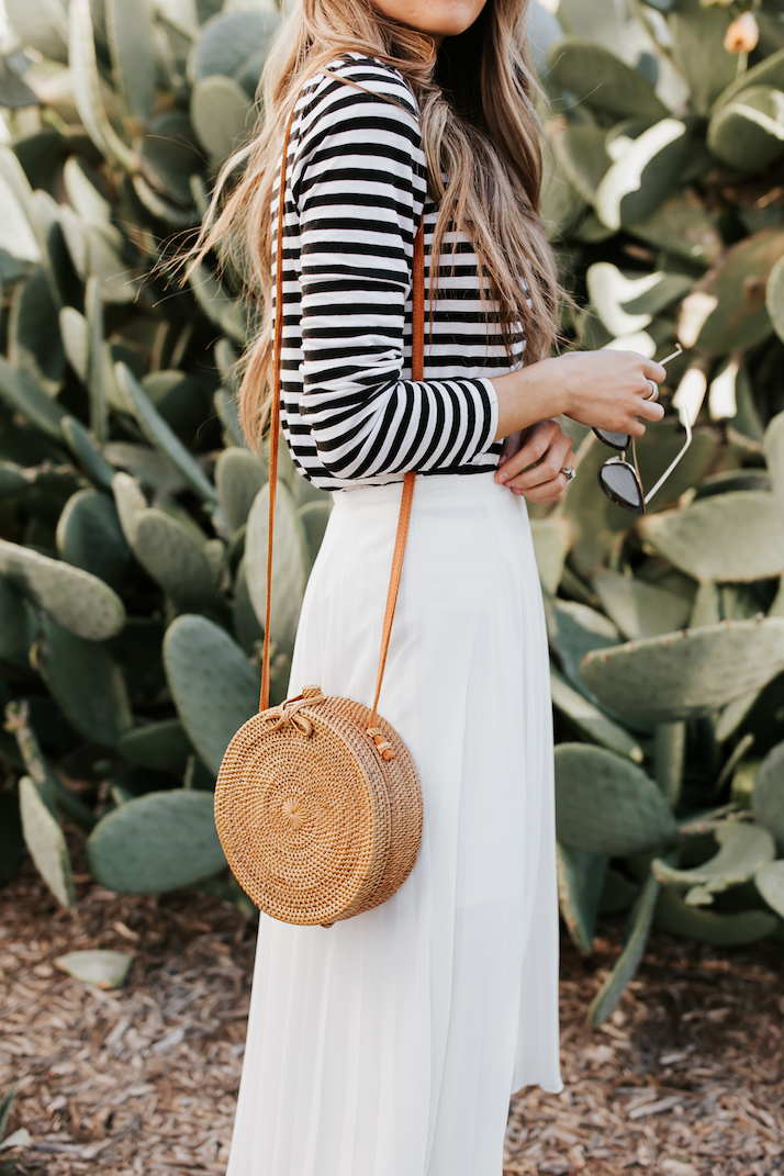 round woven bag and pleated midi skirt