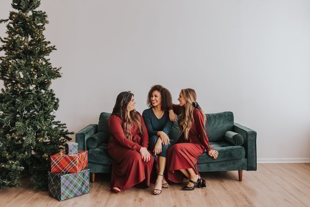 dark red midi dress dark teal midi dress girls sitting on a green velvet couch