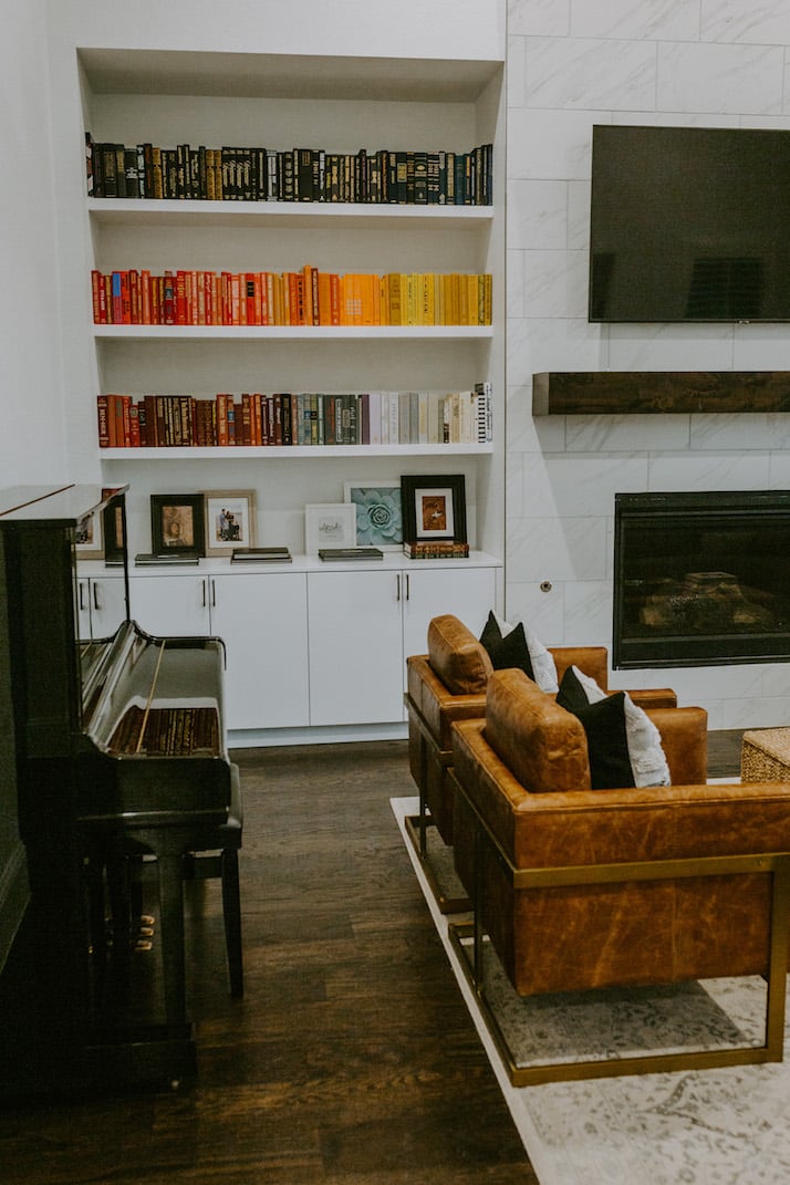 red yellow and black books in a living room with brown leather chairs