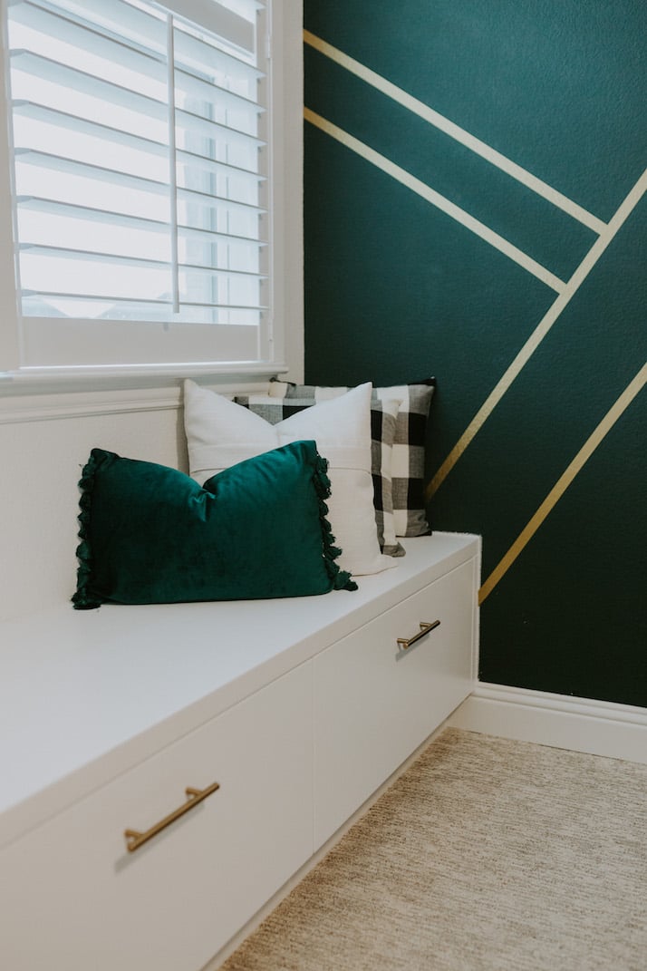 gold and green wall with white built in window seat