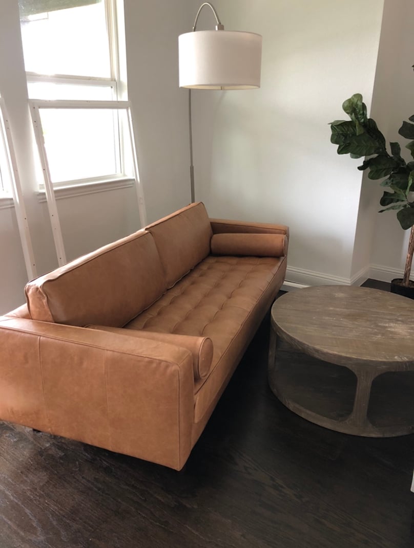brown tufted couch with round coffee table