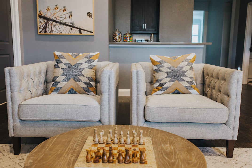 gray tufted chairs with round table and chessboard