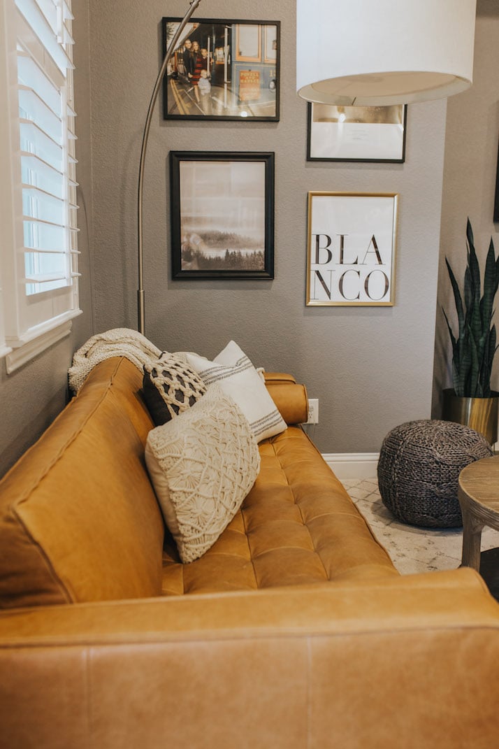 brown tufted couch with gray paint and gallery wall