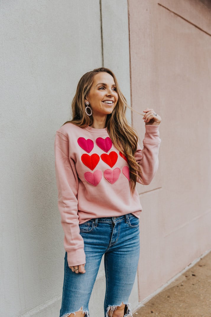 pink sweatshirt with hearts and blue levi's jeans