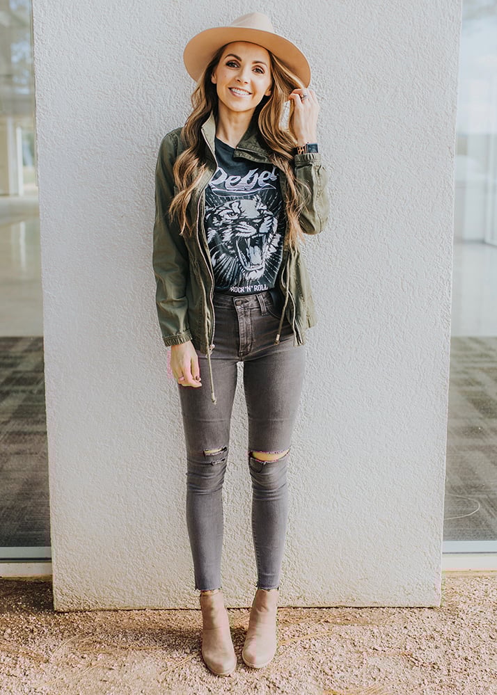 olive green utility jacket with graphic tee and jeans