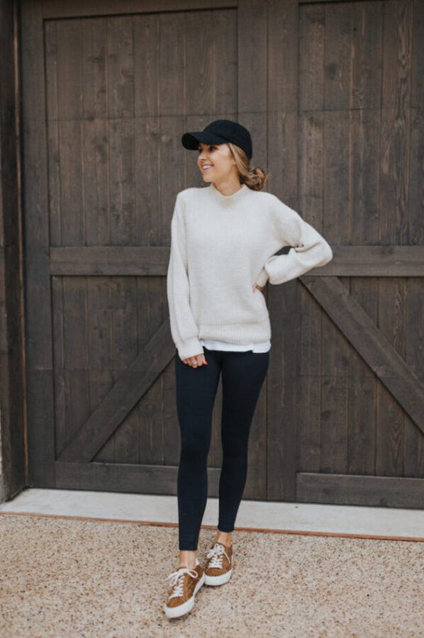 cream sweater, black leggings, black baseball cap