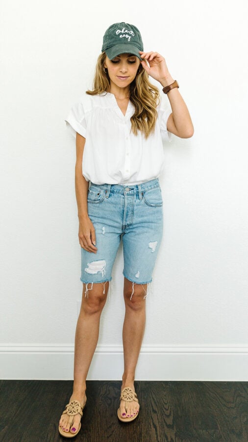 denim shorts, white shirt, with a baseball cap