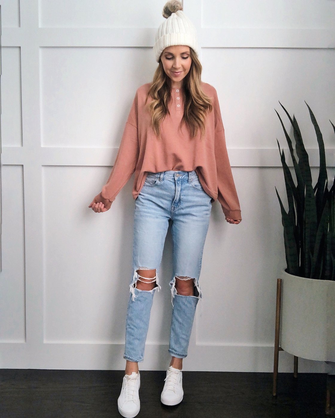 white sneakers in the fall: pink sweatshirt and light wash jeans