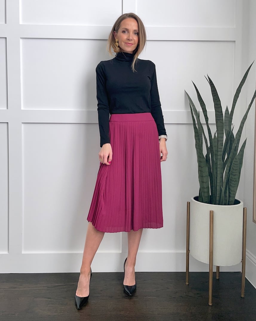 pink pleated midi skirt and black turtleneck
