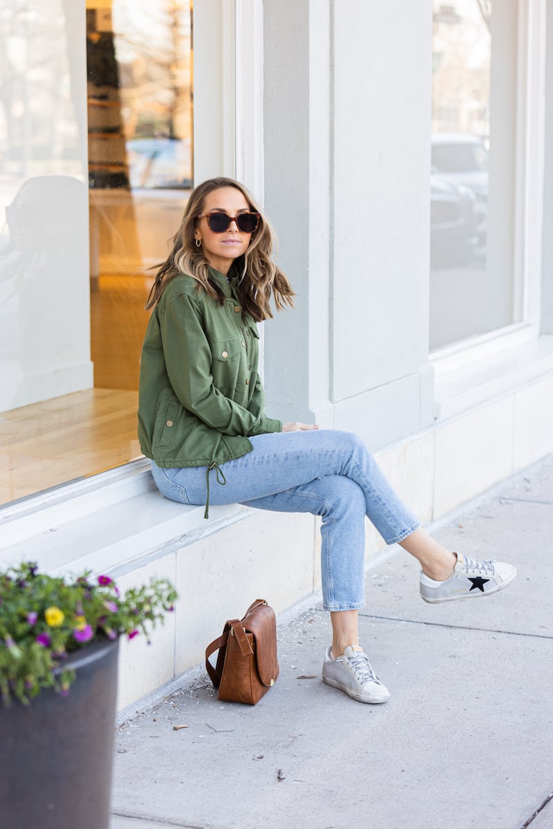 green jacket with golden goose sneakers and lightwash jeans